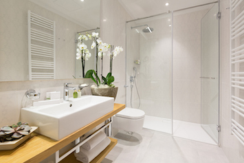 Inloopdouche met lage opstap en glazen wand in een moderne badkamer